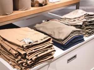 Aufgestapelte Pullover und Hosen von Masons